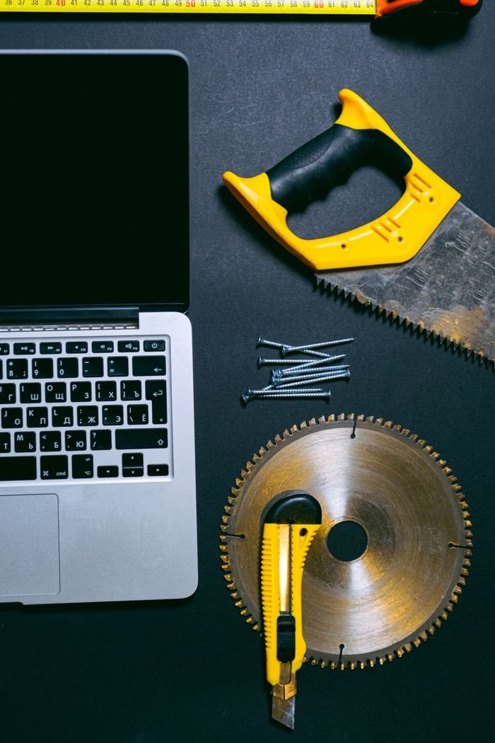 Crafting Captivating Headlines: Your awesome post title goes here Flat lay of a laptop and various hand tools on a dark surface, perfect for DIY or technology themes.